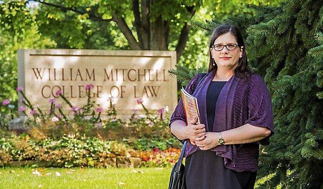Image of Sarah Deer in front of the William MItchell College of Law sign